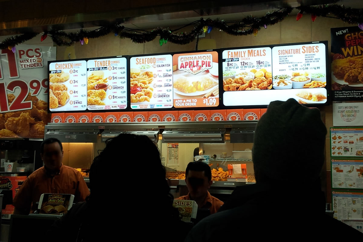 Digital menu boards at a restaurant counter